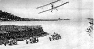 Curiosa fotografía en que Wifredo Ricart, en su avioneta Gipsy Moth sobrevuela unos coches de carreras Ricart en el circuíto de Terramar-Sitges. Años 1920’s